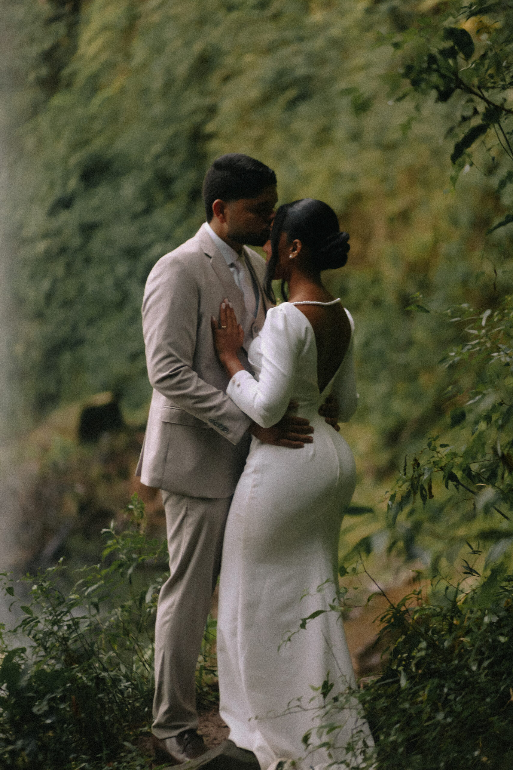 Casal se abraça em meio à natureza.